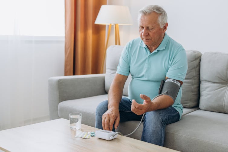 Older man testing blood pressure.
